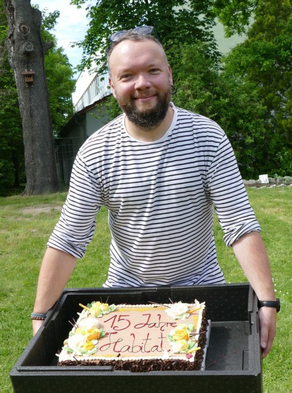 Thomas Heinze mit Kuchenblech beim Jubiläum Habitat