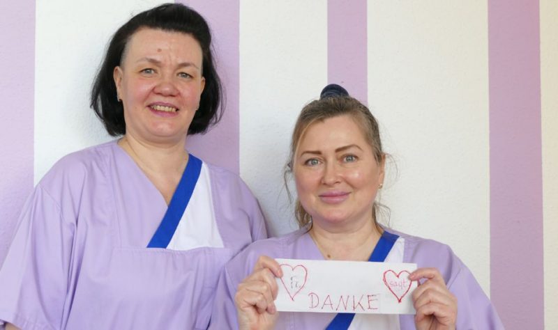 Zwei ukrainische Pflegerinnen mit Dankeschön-Zettel von einer Heimbewohnerin